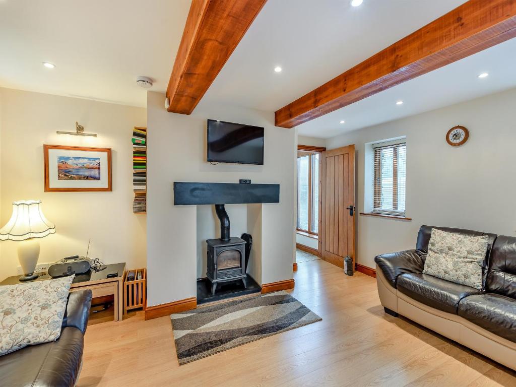 a living room with a fireplace and a couch at Stewner Bank Cottage in Ulverston