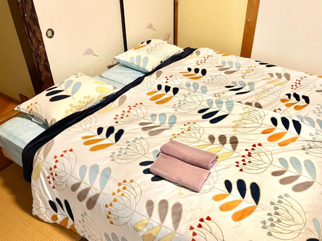 Una cama con un edredón con pisadas. en ゲストハウスわかばGuestHouse Wakaba in Iwami en Iwamicho