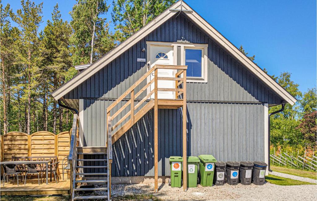 una casa pequeña con una escalera y cubos de basura en 3 Bedroom Amazing Apartment In Gotlands Tofta, en Gnisvärd