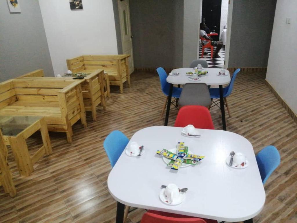een klaslokaal met witte tafels en blauwe stoelen bij Danson Lodge Guest House in Pokuase