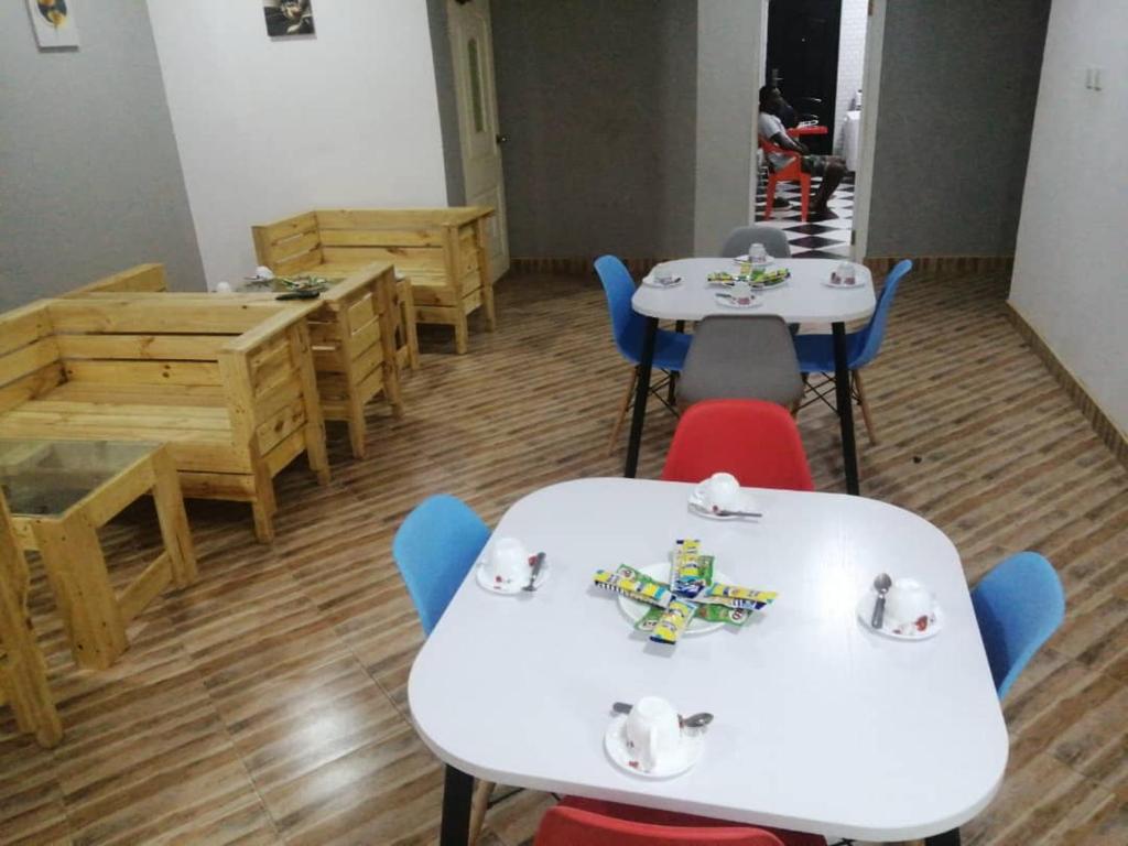 a classroom with white tables and blue chairs at Danson Lodge Guest House in Pokuase