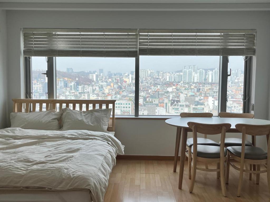 - une chambre avec un lit, une table et des chaises dans l'établissement 1 Minute house from Hongdae, à Séoul