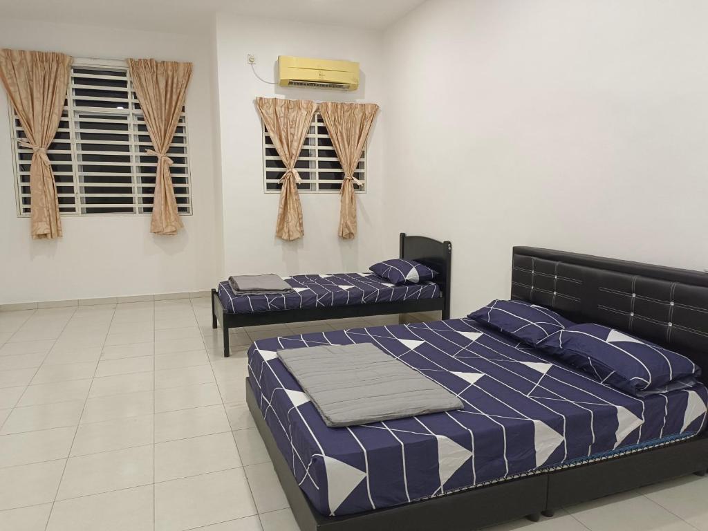 een slaapkamer met 2 bedden en airconditioning bij Happy homestay sitiawan in Sitiawan