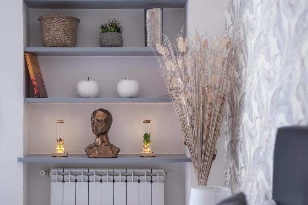 a shelf with a statue and candles in a room at Vatican Corner Family Apartment in Rome