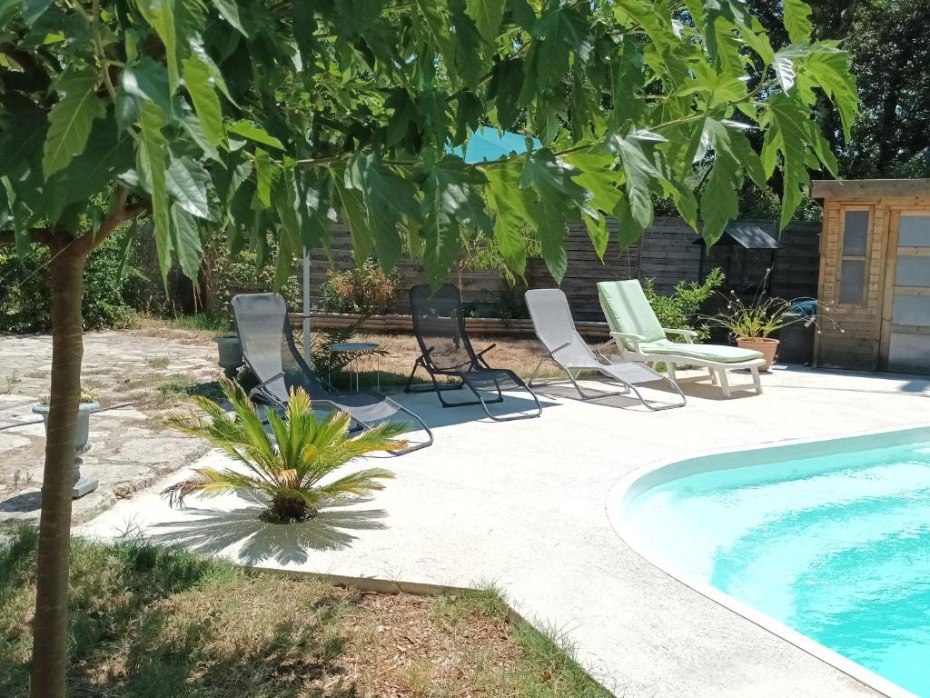 un patio con sillas y una piscina en Gîte 4 places St Bauzille de Montmel, en Saint-Bauzille-de-Montmel