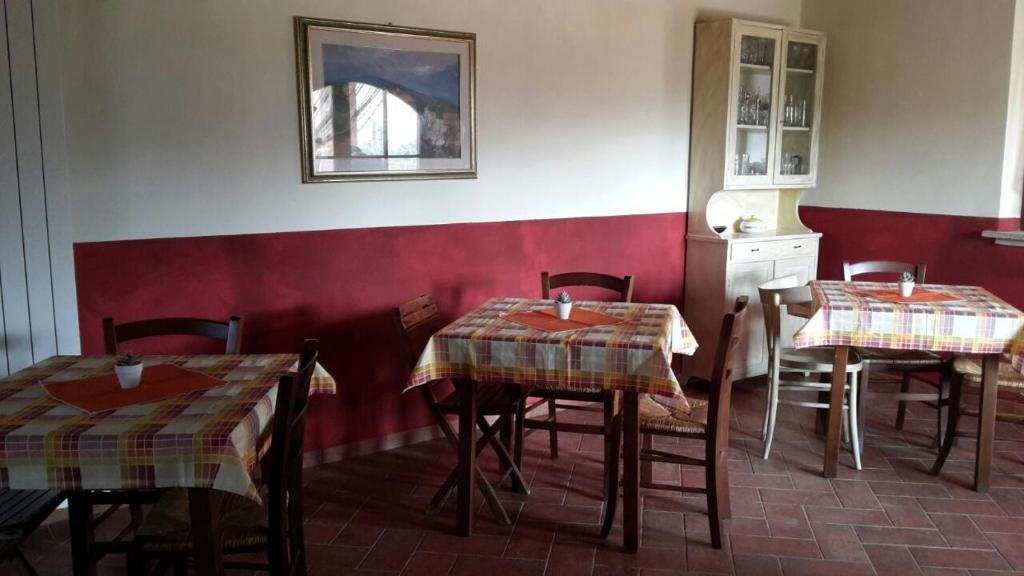 a restaurant with two tables and a red wall at Agriturismo Santa Adriana in Volterra