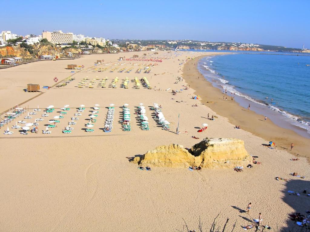 a beach with a lot of people and umbrellas at Mira Sol - Silhueta Citadina in Portimão