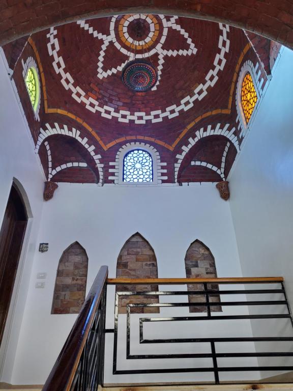 a stairway with a painting on the ceiling of a building at Laila Flat in Al Aqālitah