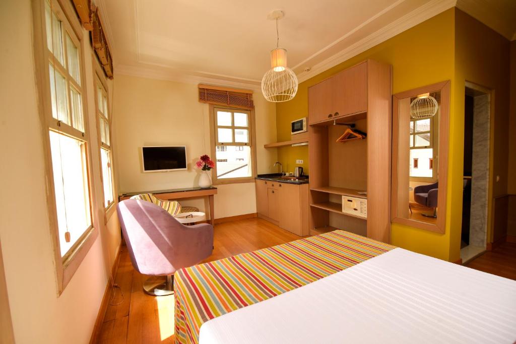 a bedroom with a white bed and a kitchen at Exceptional Studio Flat near Hadrian&#39;s Gate in Antalya