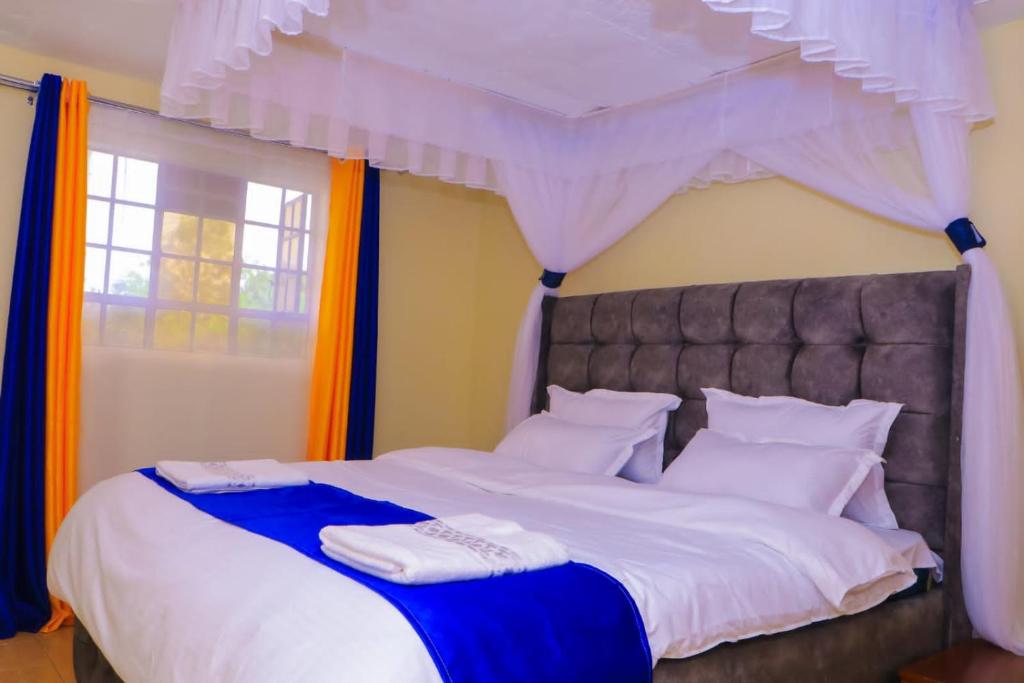 a bedroom with a large bed with a canopy at Cool & Calm Home in Homa Bay