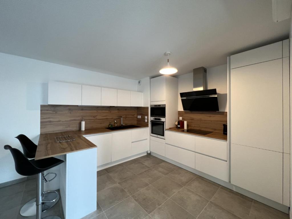 a kitchen with white cabinets and a counter top at Le Cartoucherie - 4p - Parking - Tram & Zénith in Toulouse