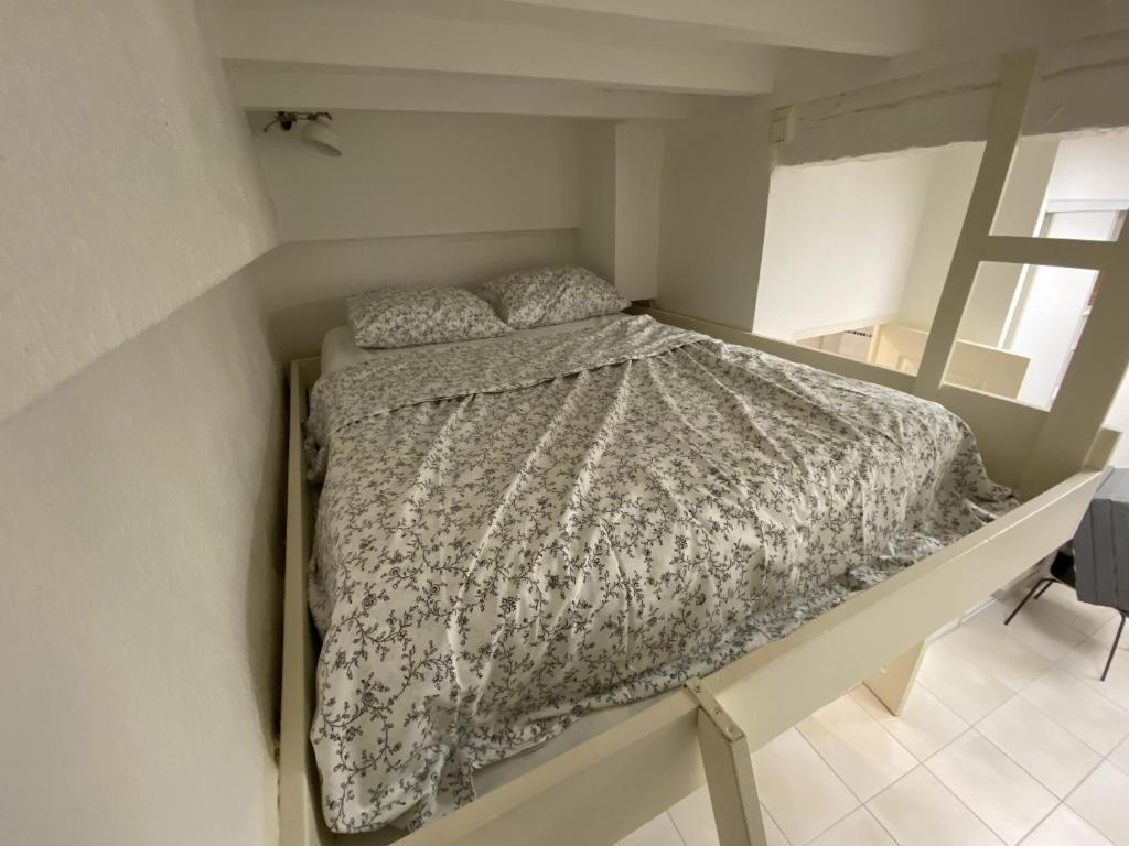 um quarto com uma cama num pequeno quarto em La Caverne - Studio au Capitole em Toulouse