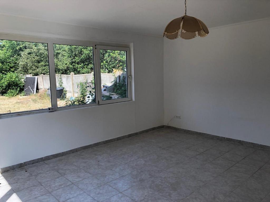 Cette chambre vide dispose de carrelage et de deux fenêtres. dans l'établissement Feel Natural and Relaxed in a 3 Bedroom B Apartment in Gyongyosfalu, à Gyöngyösfalu