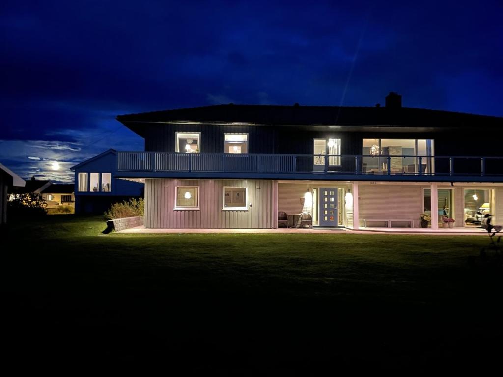 una casa grande por la noche con las luces encendidas en Apartment Utsikten en Andenes