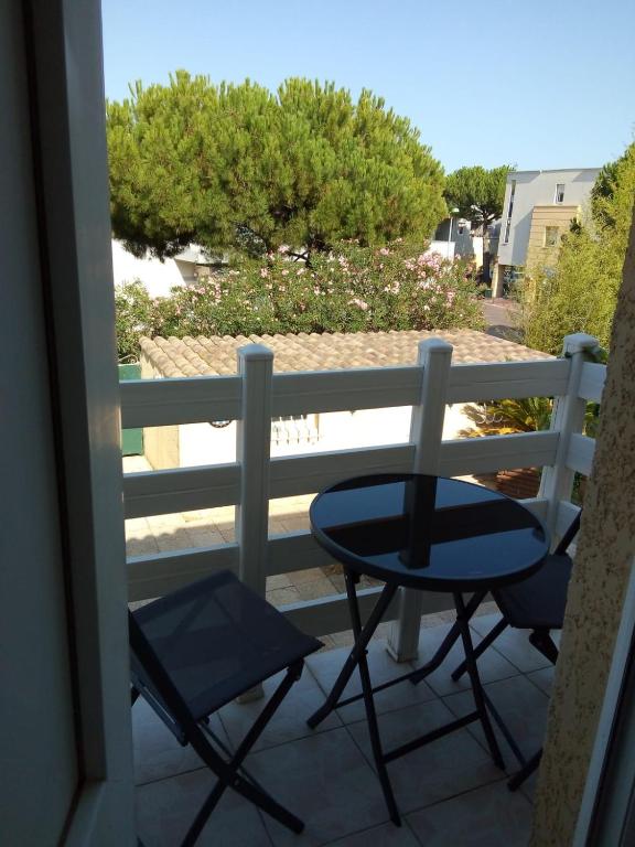une table et deux chaises sur un balcon dans l'établissement La Favola, à Mèze