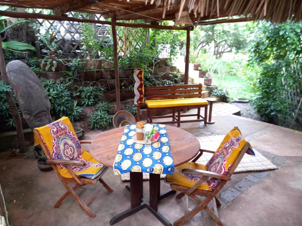 een patio met een tafel en 2 stoelen en een tafel bij Casa Camaleao Gekko Cottadge in Praia do Tofo