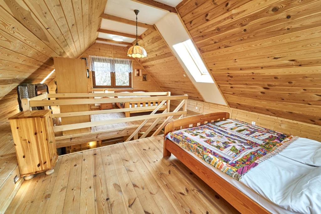 sypialnia z łóżkiem w drewnianym domku w obiekcie Marel-Apartments Domek Eva - Polanica Zdrój w Polanicy Zdroju