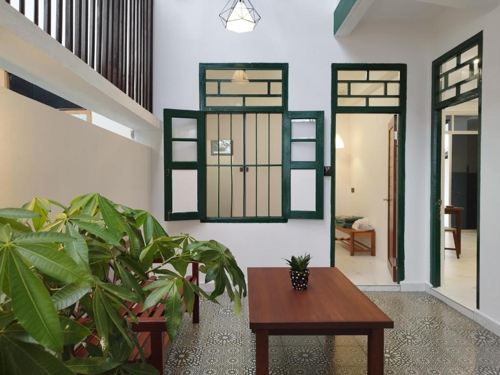 un salon avec une table et une plante dans l'établissement Nanyang Homestay 3 rooms 10 pax- Ground Floor, à Sibu