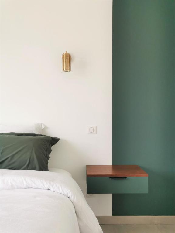 une chambre avec un lit et une table de chevet en bois dans l'établissement Au Jardin des Deux Roches, à Prissé