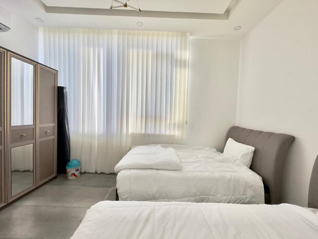 1 dormitorio con 2 camas, tocador y espejo en Granada Villas en Jericho