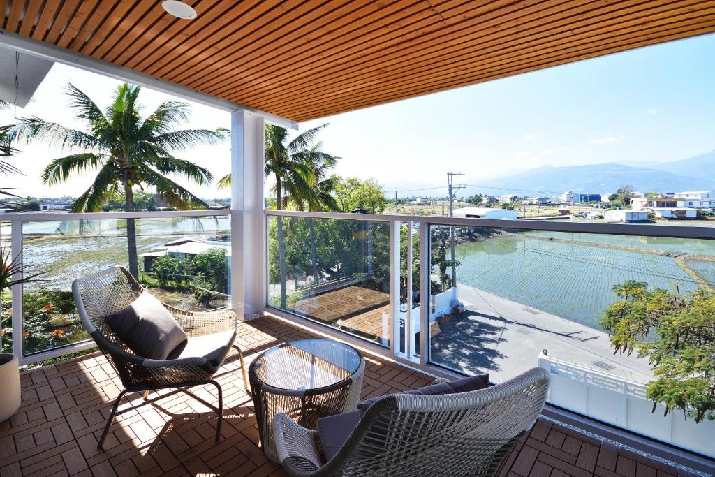 a balcony with chairs and a view of a swimming pool at 文旅行民宿-莊園館-寵物友善 in Taitung City