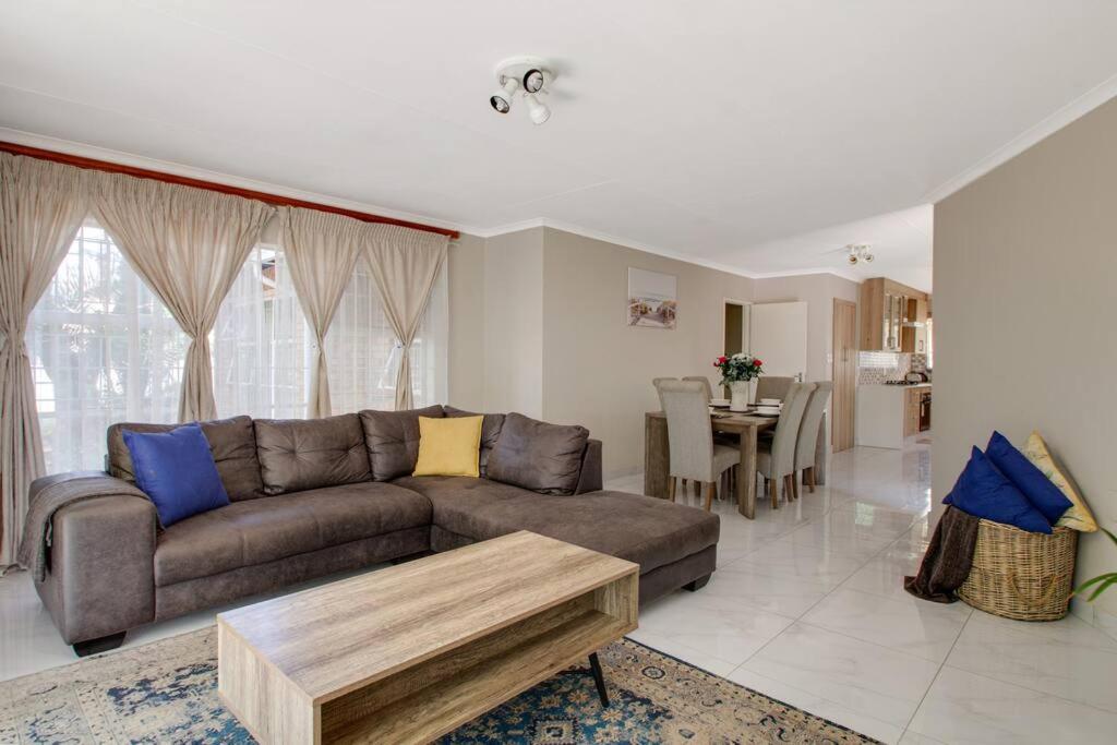 uma sala de estar com um sofá e uma mesa em The Cycad. 4-Bed Home next to Clearwater Mall em Roodepoort