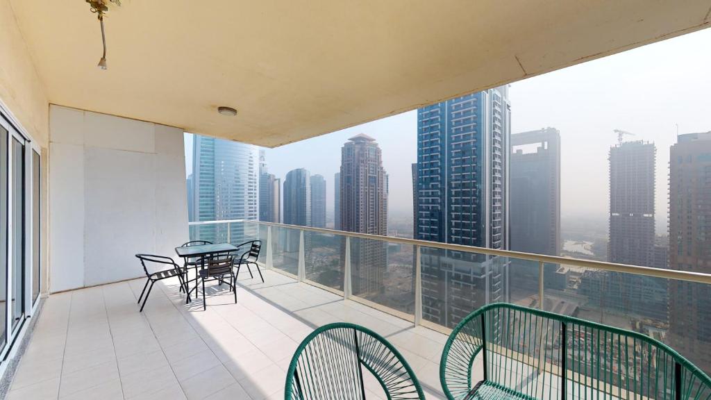 einen Balkon mit einem Tisch und Stühlen auf einem Gebäude in der Unterkunft LV38 - Elegant 2BHK in Lake View Tower in Dubai