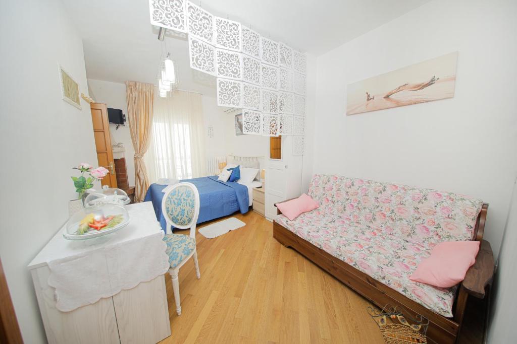 Habitación pequeña con cama y mesa con silla. en Io, te e il mare en Polignano a Mare