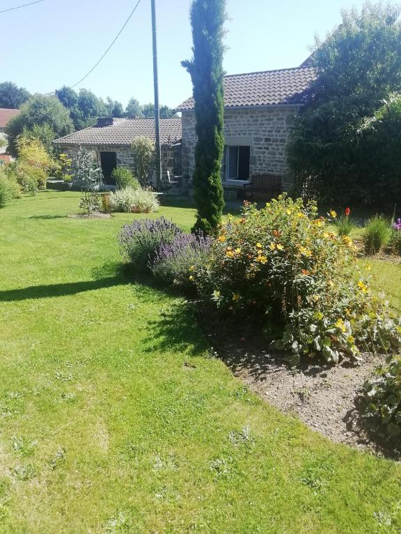 un jardín con flores frente a una casa en Gîte de caractère en Thauron