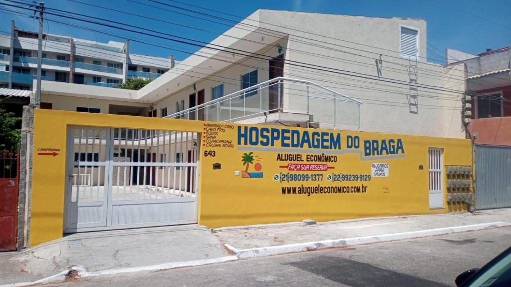 um edifício amarelo com um sinal na lateral em Cabo Frio - Braga - Kitnets - Aluguel Econômico em Cabo Frio