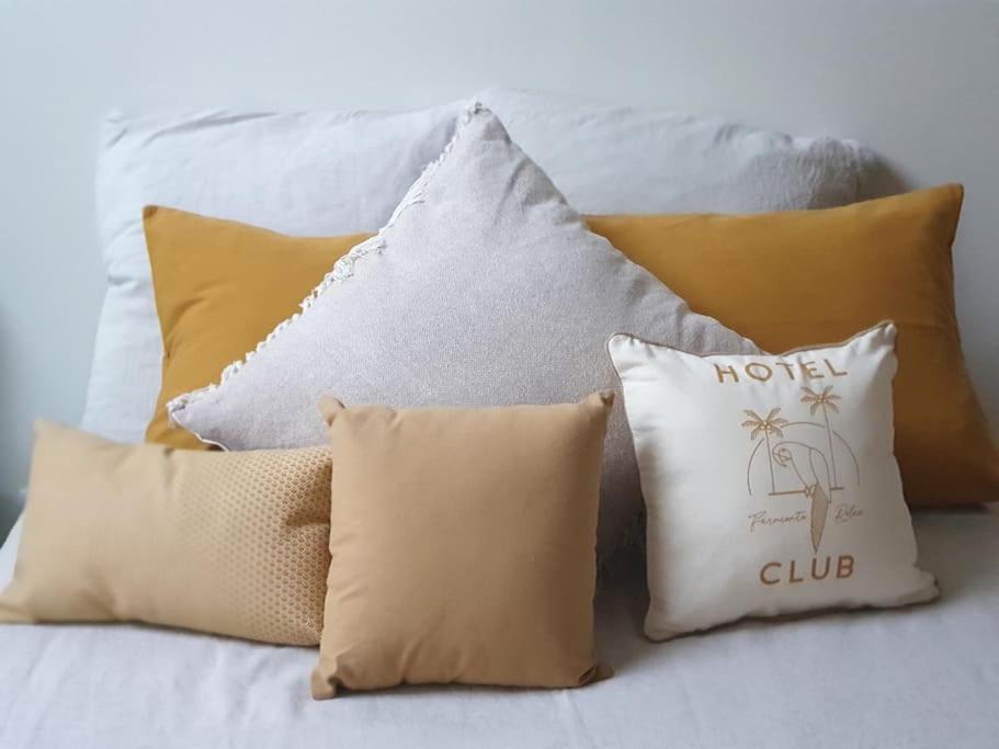 a bunch of pillows sitting on a bed at Logement Cosy 2 à 4 Personnes Campagne proche Mer in Frossay