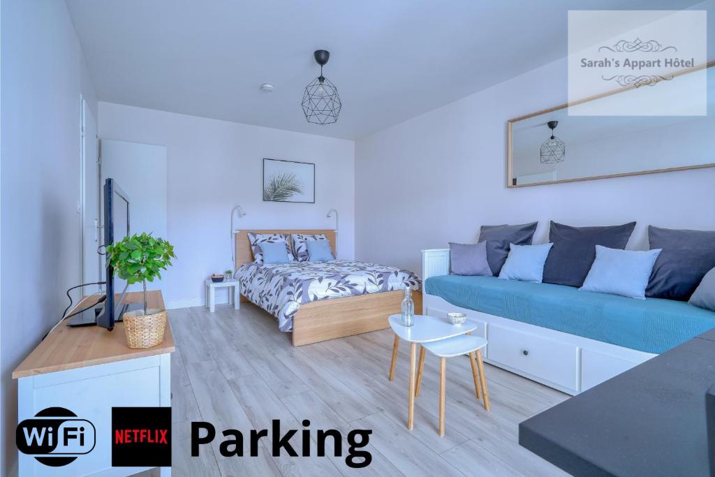Logement Elia في Courcouronnes: غرفة معيشة مع أريكة زرقاء وسرير