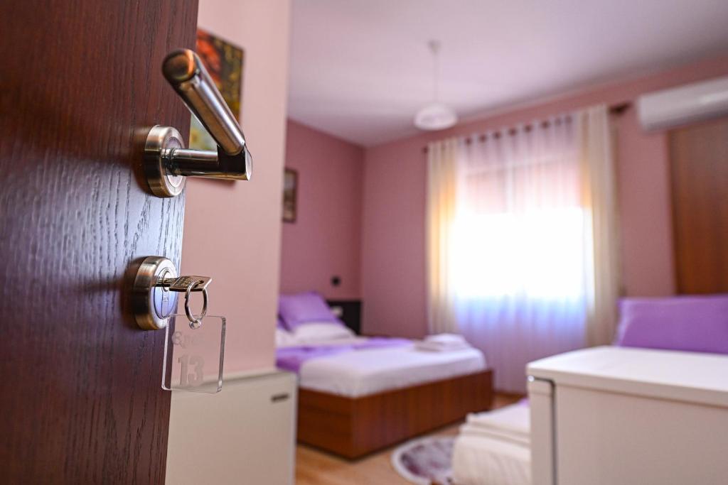 a room with a door with a room with two beds at Hotel Epoka in Shkodër