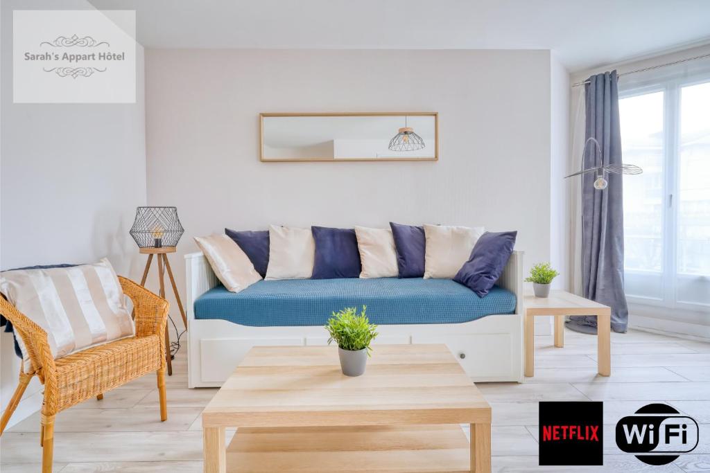 uma sala de estar com um sofá azul e uma mesa em Logement Sarah em Courcouronnes