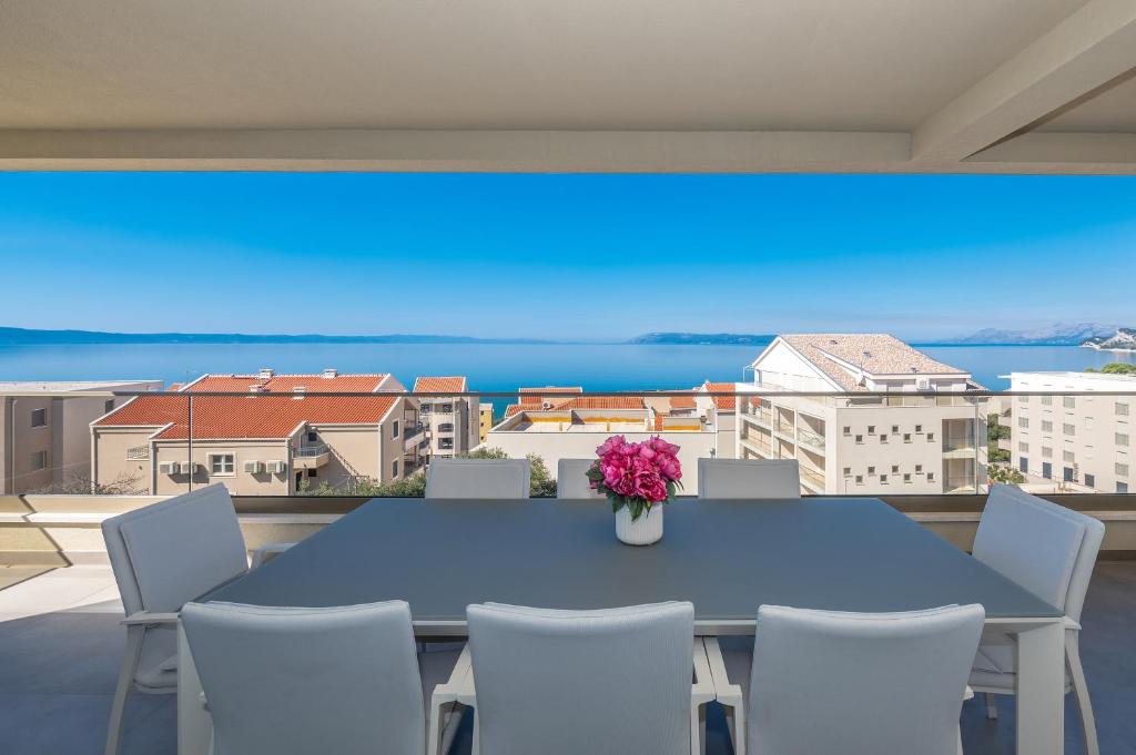 圖策比的住宿－-NEW 2023- Apartment Adriatic Pearl，阳台配有一张蓝色的桌子和椅子,设有大屏幕