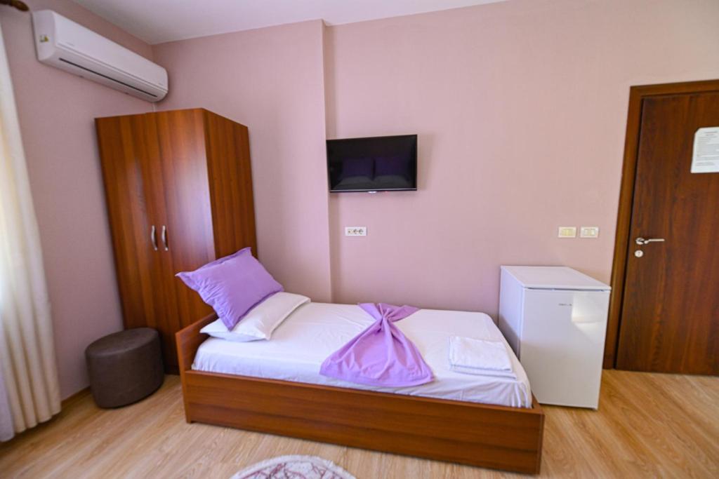 a small bedroom with a bed and a tv at Hotel Epoka in Shkodër