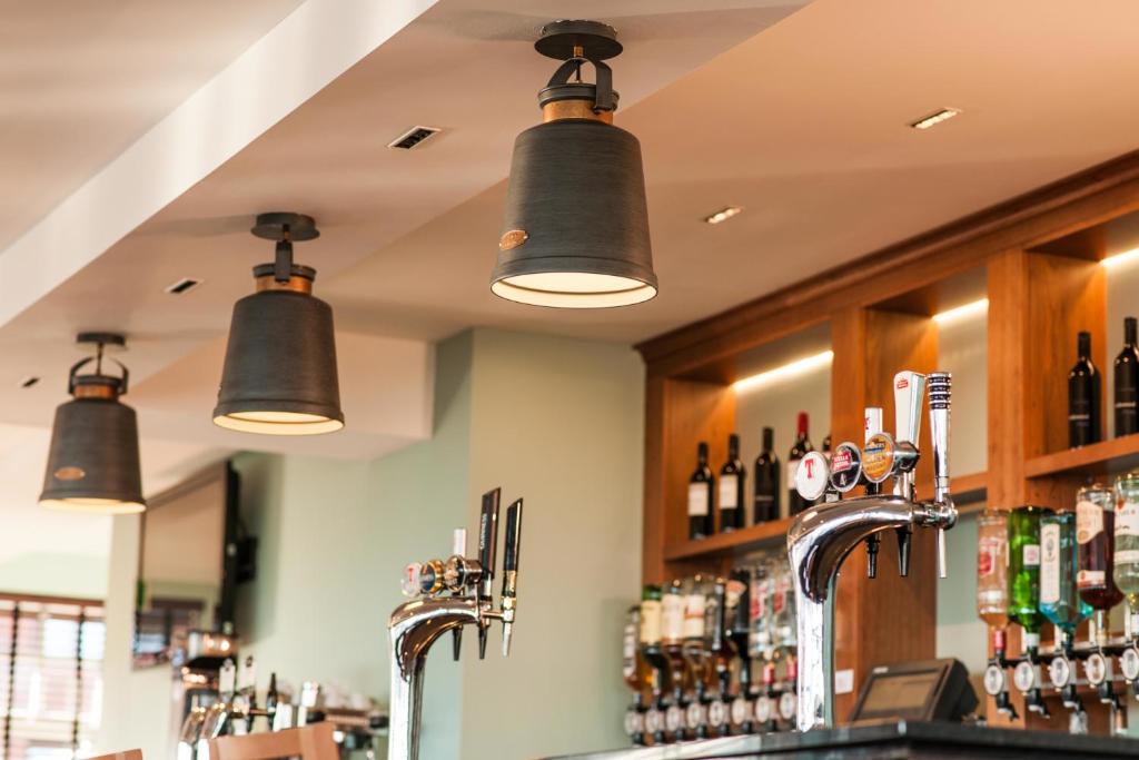 a bar with black bells hanging from the ceiling at Leonardo Inn Aberdeen Airport in Dyce