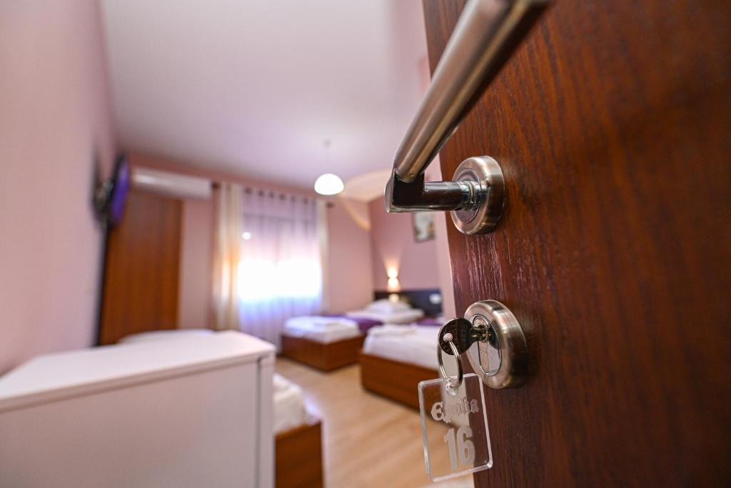 a room with a door and a room with two beds at Hotel Epoka in Shkodër