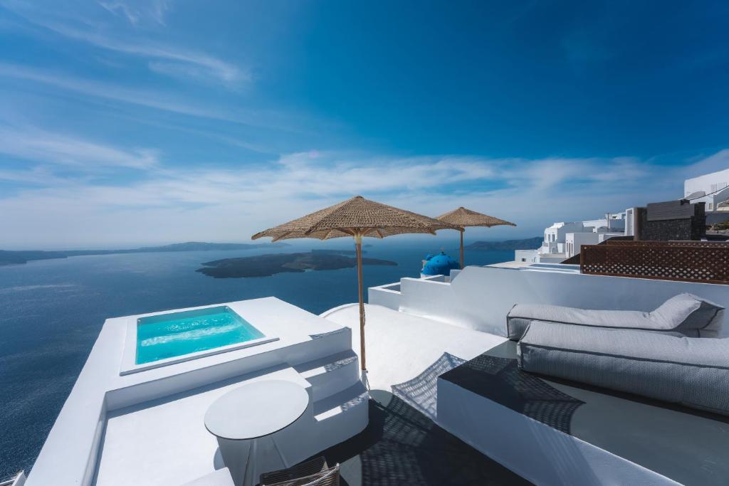 een zwembad bovenop een gebouw met uitzicht op de oceaan bij Cilon Suites Santorini in Imerovígli