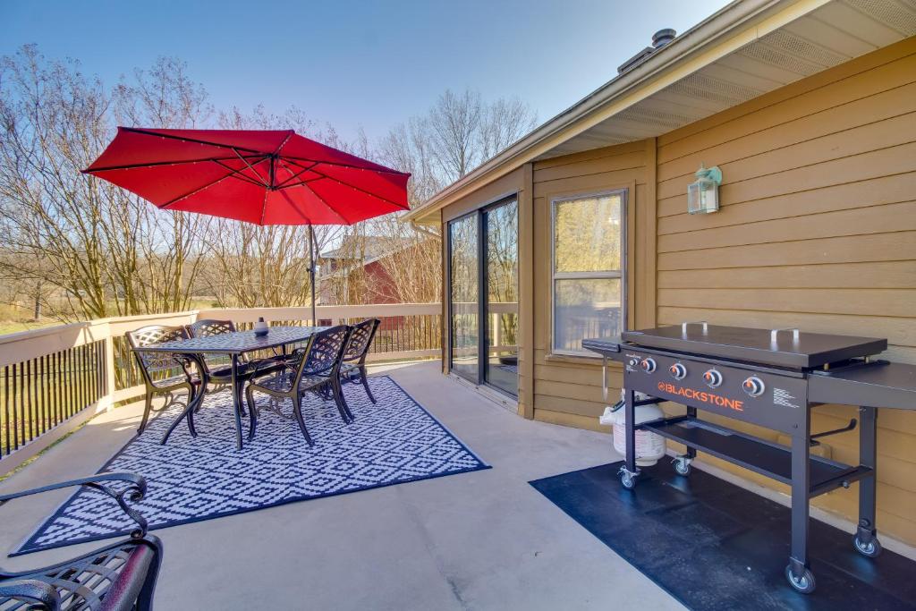 un patio con una mesa con una sombrilla roja y una parrilla en Mountain Home Vacation Rental Near Lakes and Fishing, en Mountain Home