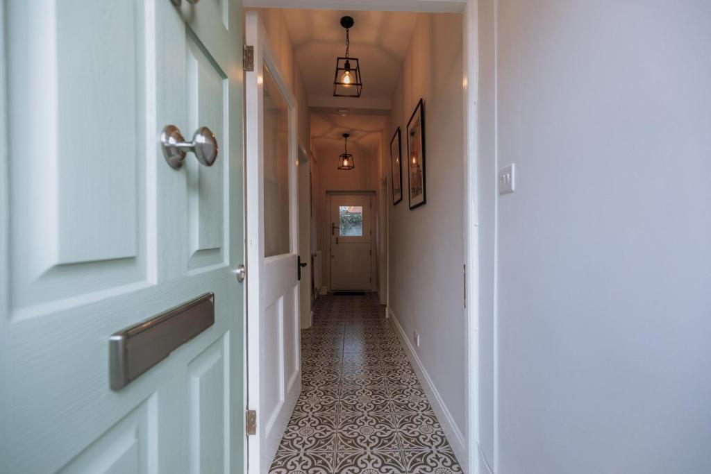 um corredor com uma porta e um piso de azulejo em Church View Cottage em Whalley