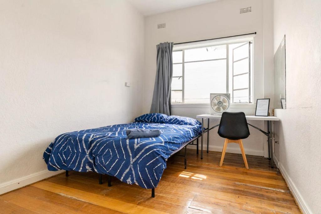 a bedroom with a bed and a desk and a window at Richmond Private Rooms - 151 Hoddle Homestay in Melbourne