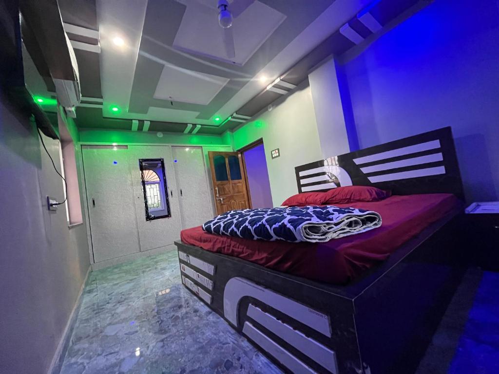 a bedroom with a bed in a room with green lights at Dusilu Homestay in Bhadrak