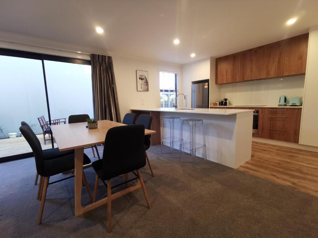 a kitchen and dining room with a table and chairs at Nelson City Town House 10 minute walk to town in Nelson
