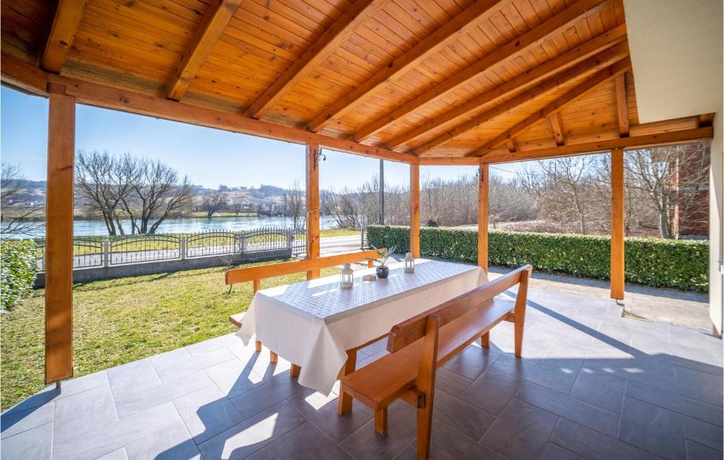 a dining room with a table and benches on a patio at Beautiful Home In Hrvatska Kostajnica With Wifi in Hrvatska Kostajnica