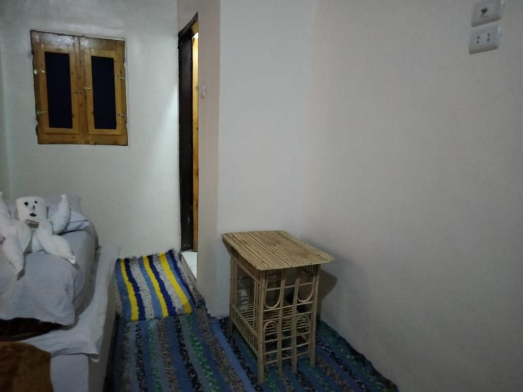 um canto de um quarto com uma cama e uma mesa em Nubian King em Aswan