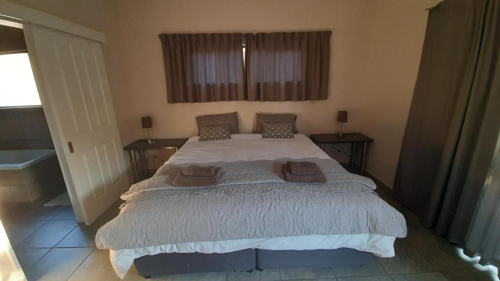 a bedroom with a large bed with two pillows on it at Oribi Gorge Villa in Glendale