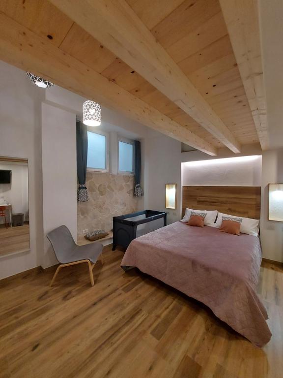 a bedroom with a large bed and a chair at Core Cagliari in Cagliari