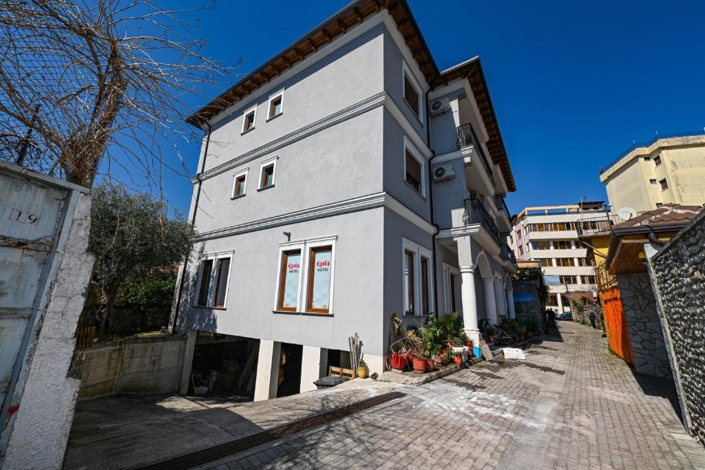 a white house on a cobblestone street at Hotel Epoka in Shkodër