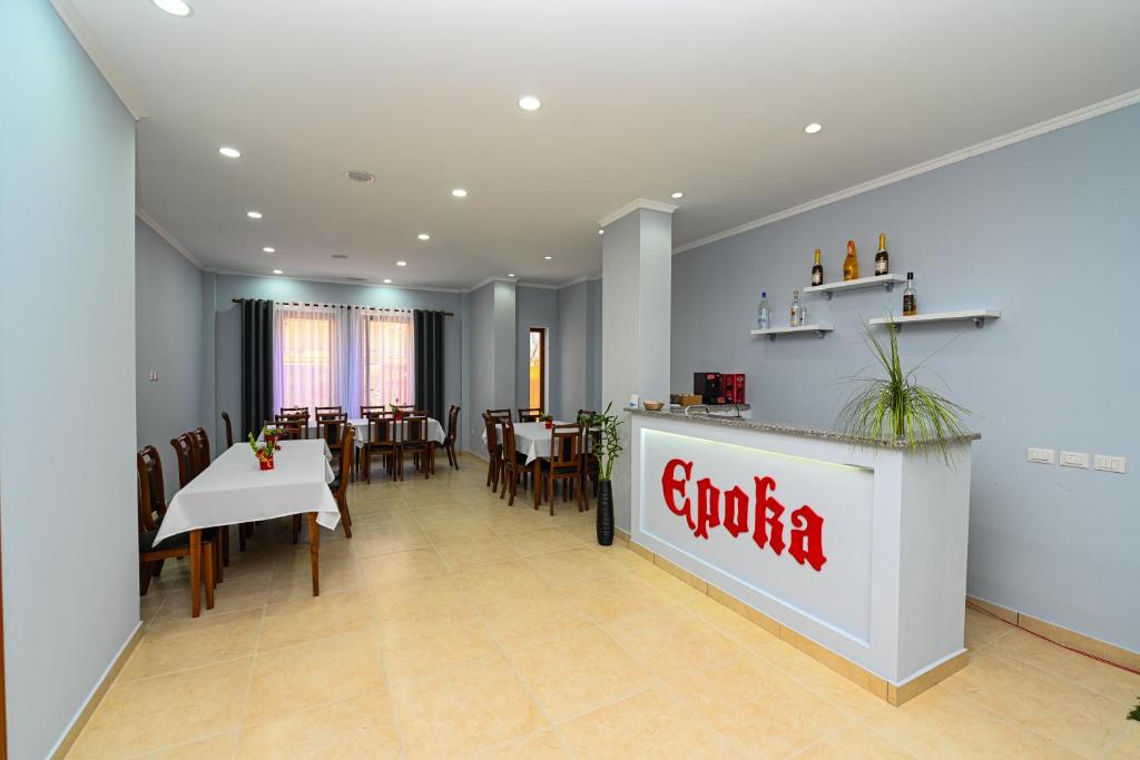 a restaurant with a grococo sign on the wall at Hotel Epoka in Shkodër